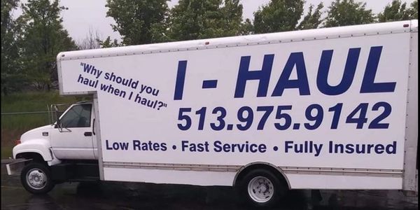 The side profile of large I-Haul truck displaying its phone number and slogan.