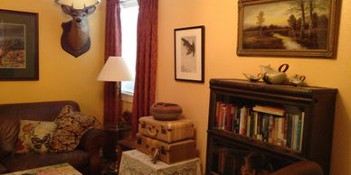 Cozy corner of Cottonwood Cottage, with deer head mount and well-stocked bookcase.