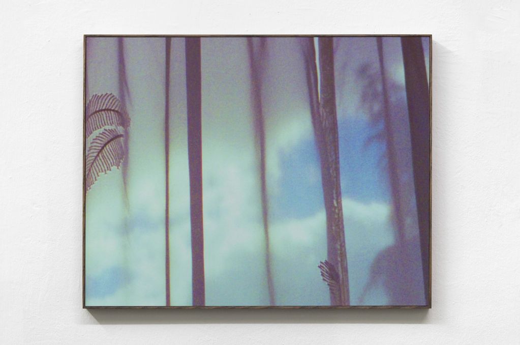 Abstract wall art with vertical lines and a leafy pattern.