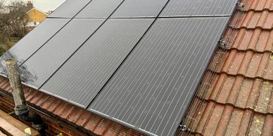 Solar panels installed on a tiled roof with protective netting.