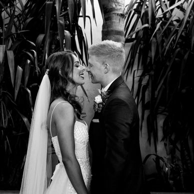 Bride and groom smiling closely in a black-and-white wedding photo.