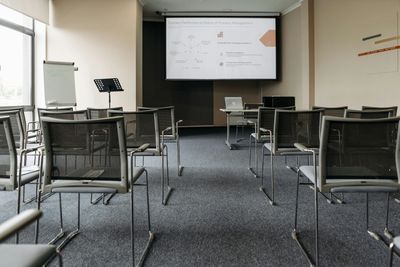 Empty conference room with chairs and a presentation screen.