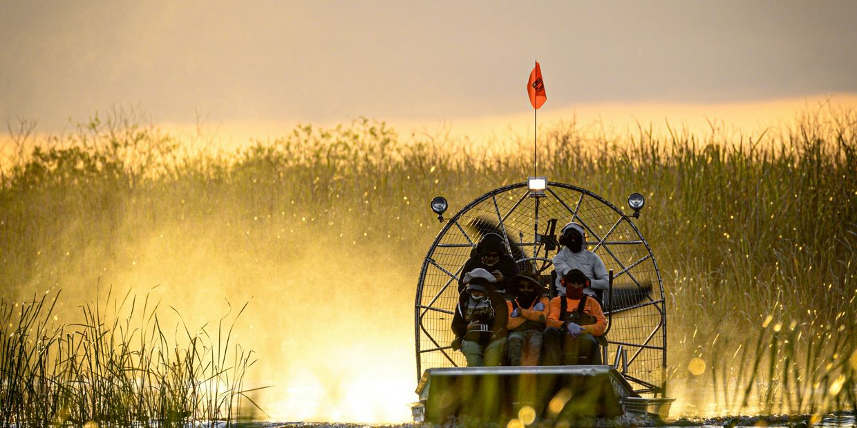 Airboat on river at sunset