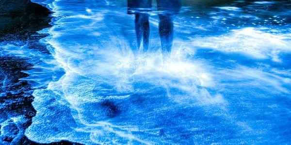 Person standing in luminescence in water