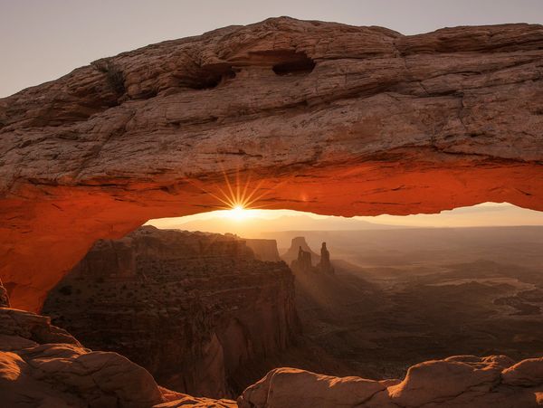 Sunset seen through red rock arch