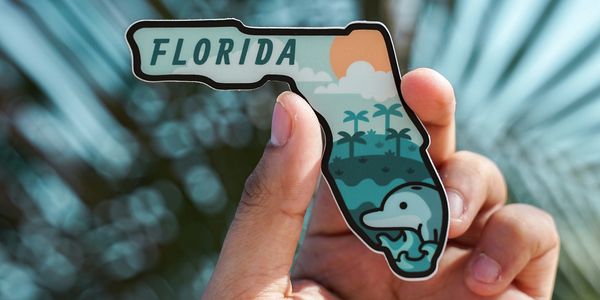 State of Florida shaped sticker held in hand