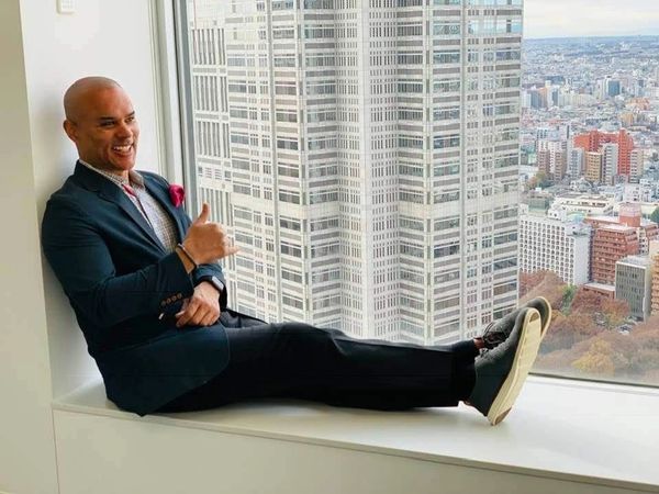 CEO is smiling in a picture while sitting in a beautiful city view in Japan.