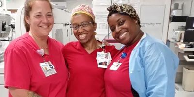 Three smiling healthcare workers in a medical setting.