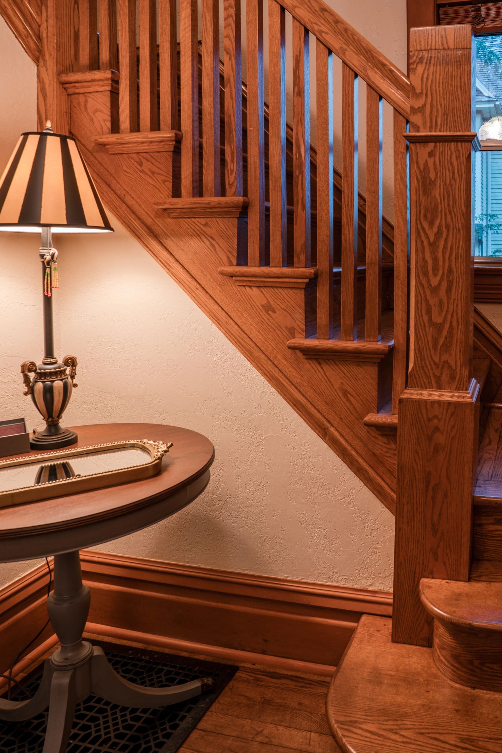 Front entryway with soft lighting and an exquisite and grand wooden staircase