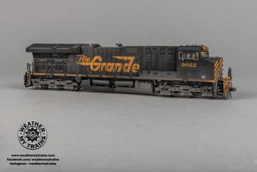 Model train locomotive painted with Rio Grande logo in black and orange.