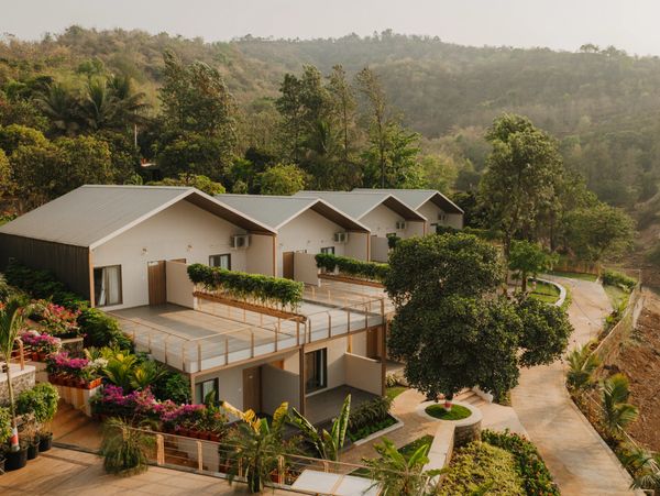 Modern hillside houses with greenery and scenic mountain views.