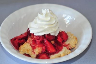 Strawberry shortcake topped with whipped cream.