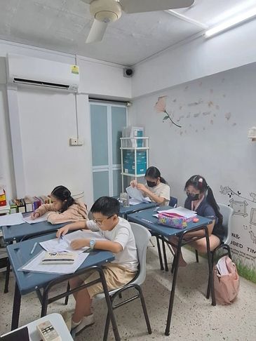 A group of students being taught by a primary math tutor.