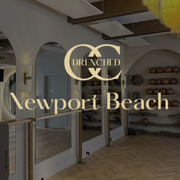 Elegant interior of Drenched Newport Beach fitness studio with mirrors and barre.