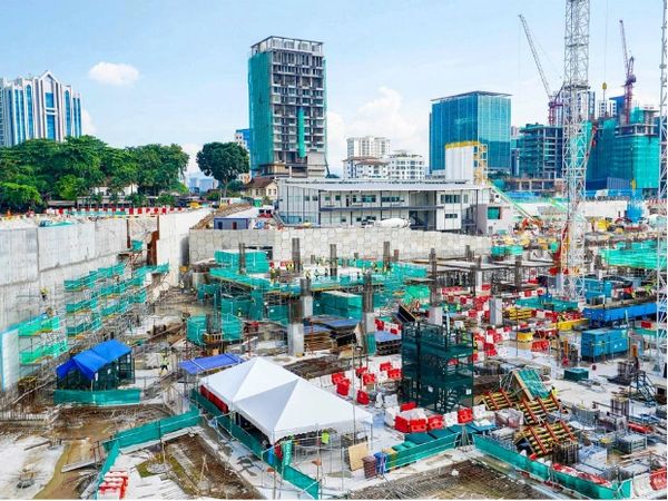 Busy urban construction site with cranes and tall buildings.