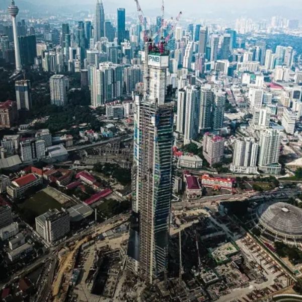 Tall skyscraper under construction in a busy cityscape.