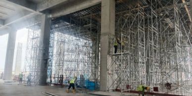 Construction workers building a large structure with scaffolding.