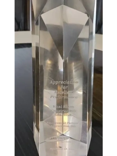 Crystal appreciation award trophy on black table.