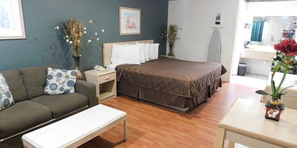 Interior picture of a hotel room with a King size bed with sofa.