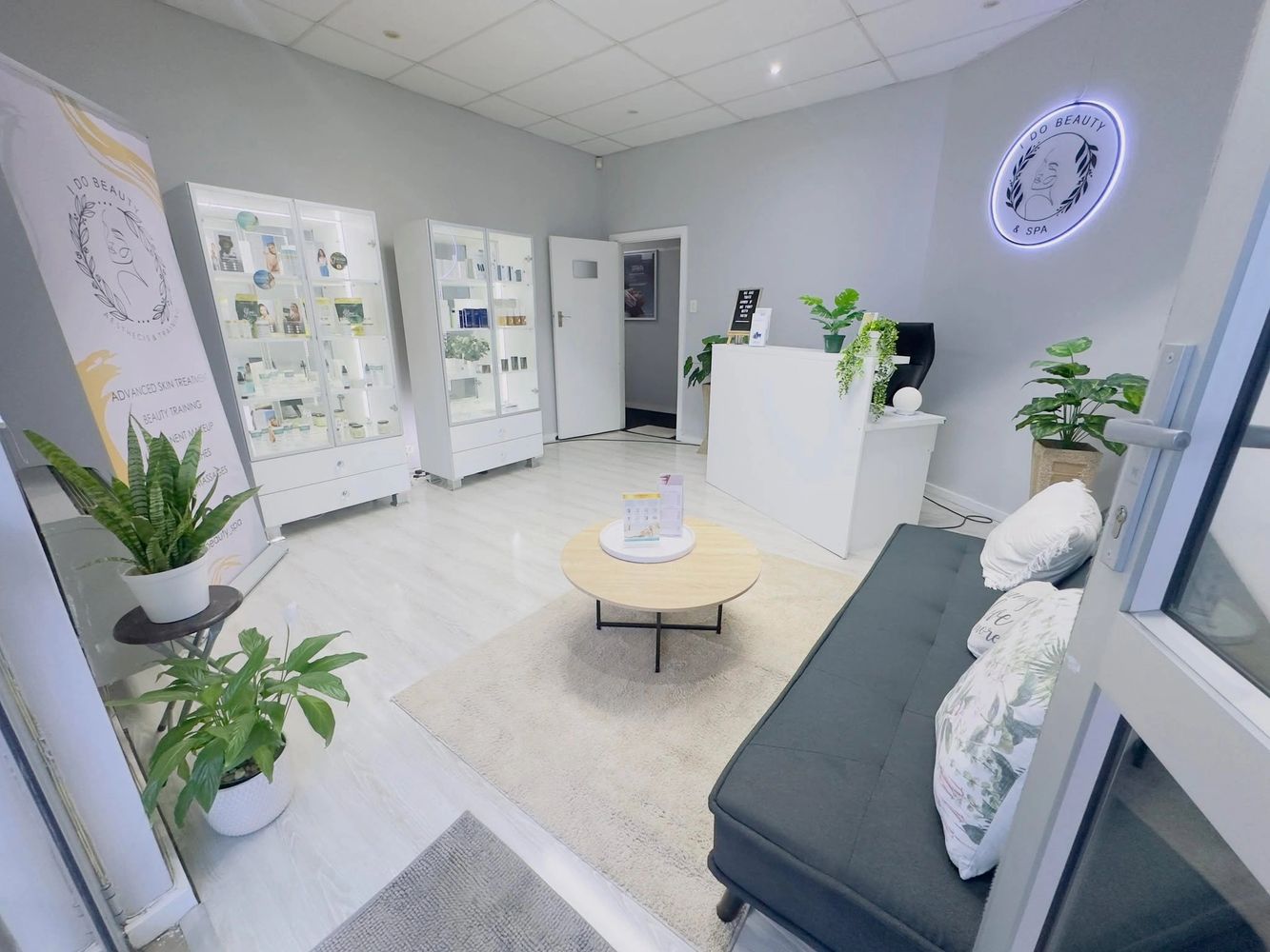 Bright and modern beauty spa reception area with plants and cozy seating.