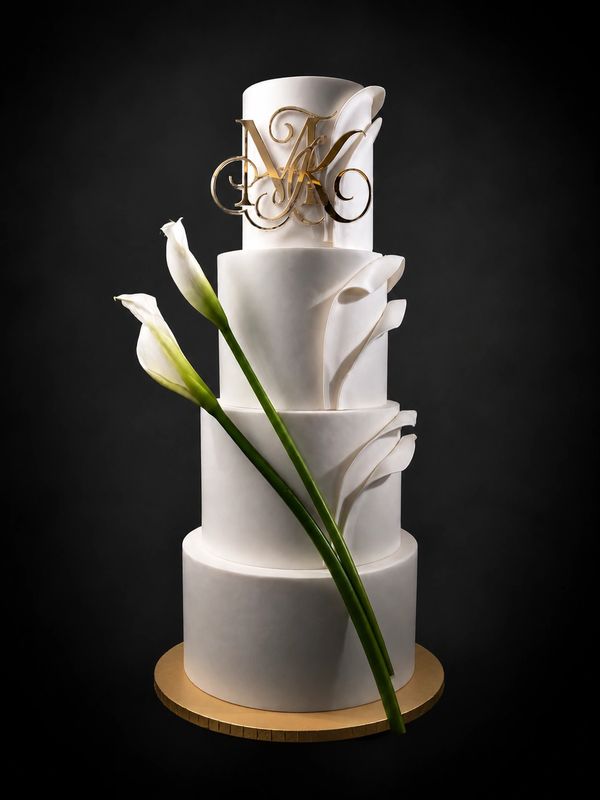 Elegant four-tier white cake with floral decorations and gold initials.