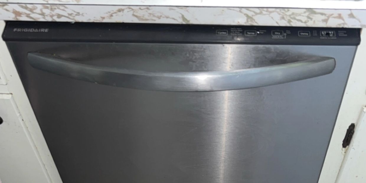 Stainless steel Frigidaire dishwasher with a curved handle.