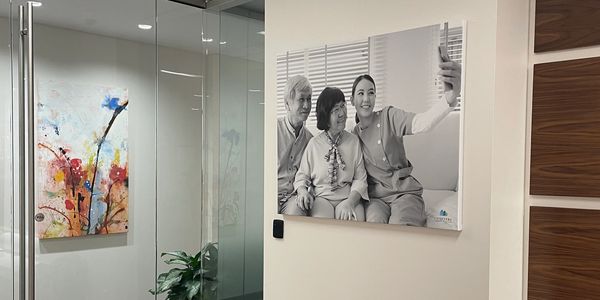 Modern office corner with colorful and black-and-white art pieces on white walls.