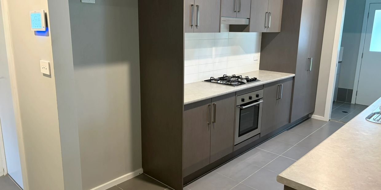 Modern kitchen with wooden cabinets and a built-in stove.
