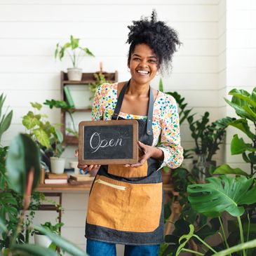 Small business owner smiling with open sign