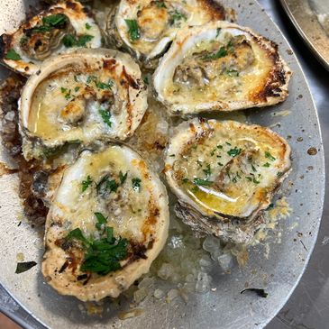 char broiled oysters on a hot plate right out of the broiler