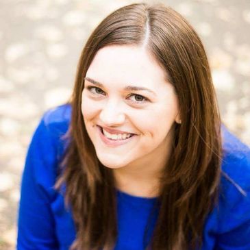 Smiling woman with brown hair in blue top.
