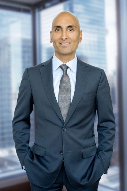 Professional man in a suit standing confidently in an office.
