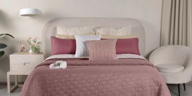 Habitación con cama rosa y decoración minimalista.