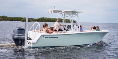 People enjoying a boat ride on calm waters near a green shoreline.