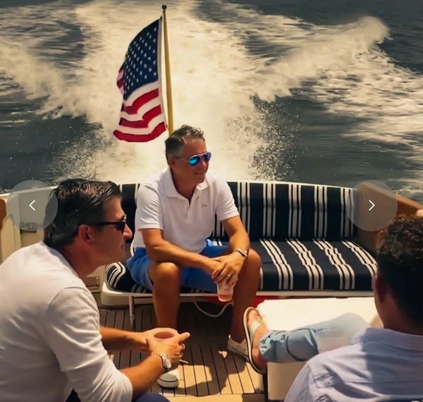 Men relaxing on a boat with an American flag.