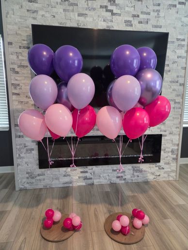 Globos de colores rosados y morados en un interior moderno.