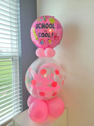 Decoración de globos rosa con tema escolar.
