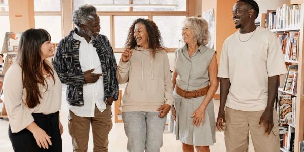 A diverse group of people laughing and walking indoors.