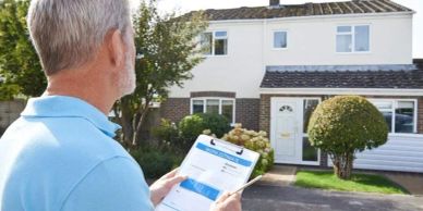 Man inspecting a house with a clipboard.