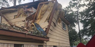 Severely damaged house with collapsed roof and walls.