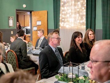 A formal sit down meal with adults and children in the banquet space of the Ovid Inn Event Center