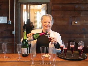 A party host serves drinks in the historic game room area of the Ovid Inn Event Center