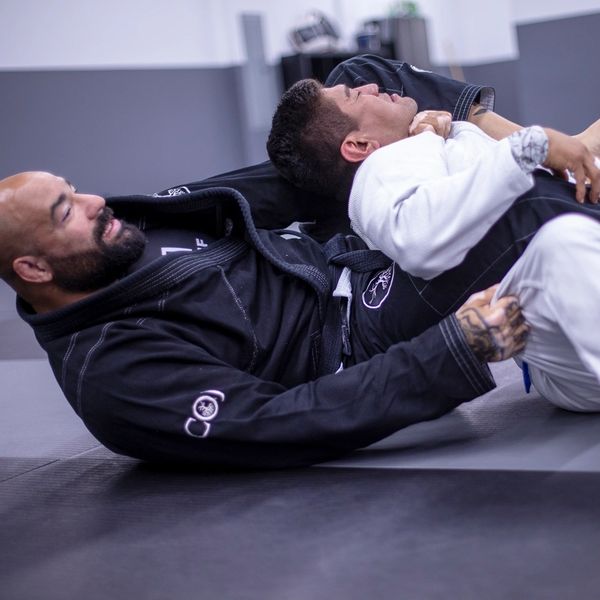 Two men practicing Brazilian Jiu-Jitsu grappling techniques.