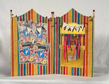 Colorful striped carnival booth with prize and ticket displays.