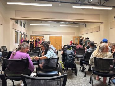 People gathered in a community room, engaged in conversations and activities.