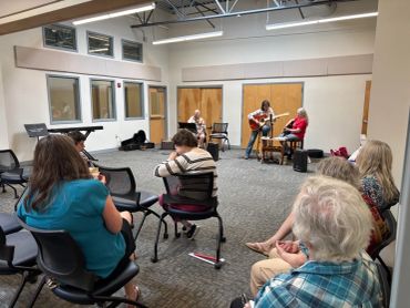 Small group gathered for an intimate music session in a community room.