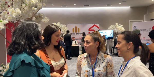 Cuatro mujeres conversan en un evento interior.