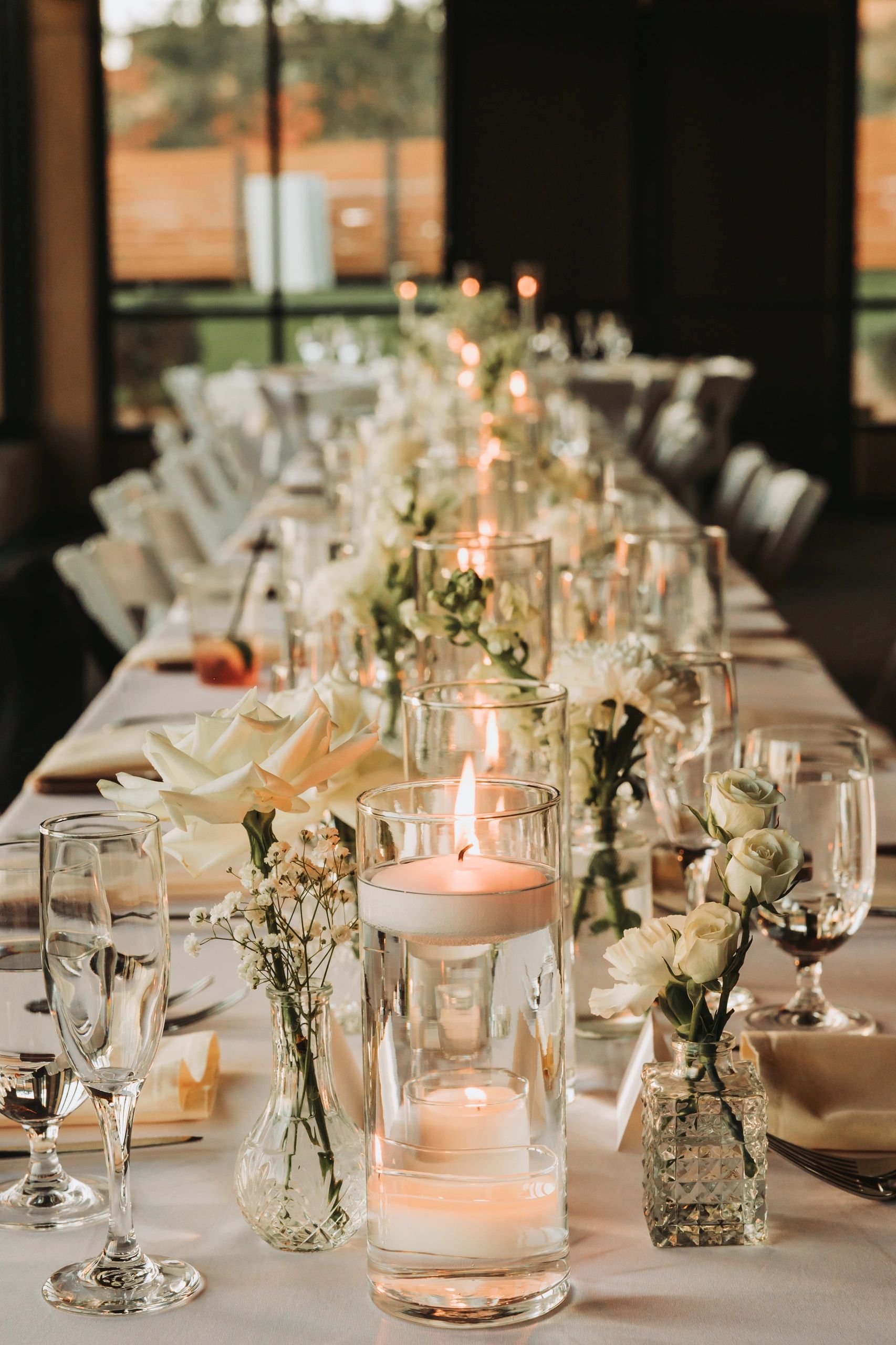 Elegant table setting with white roses and candles for a formal event.