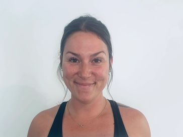 Smiling woman with dark hair in a black tank top against a white background.