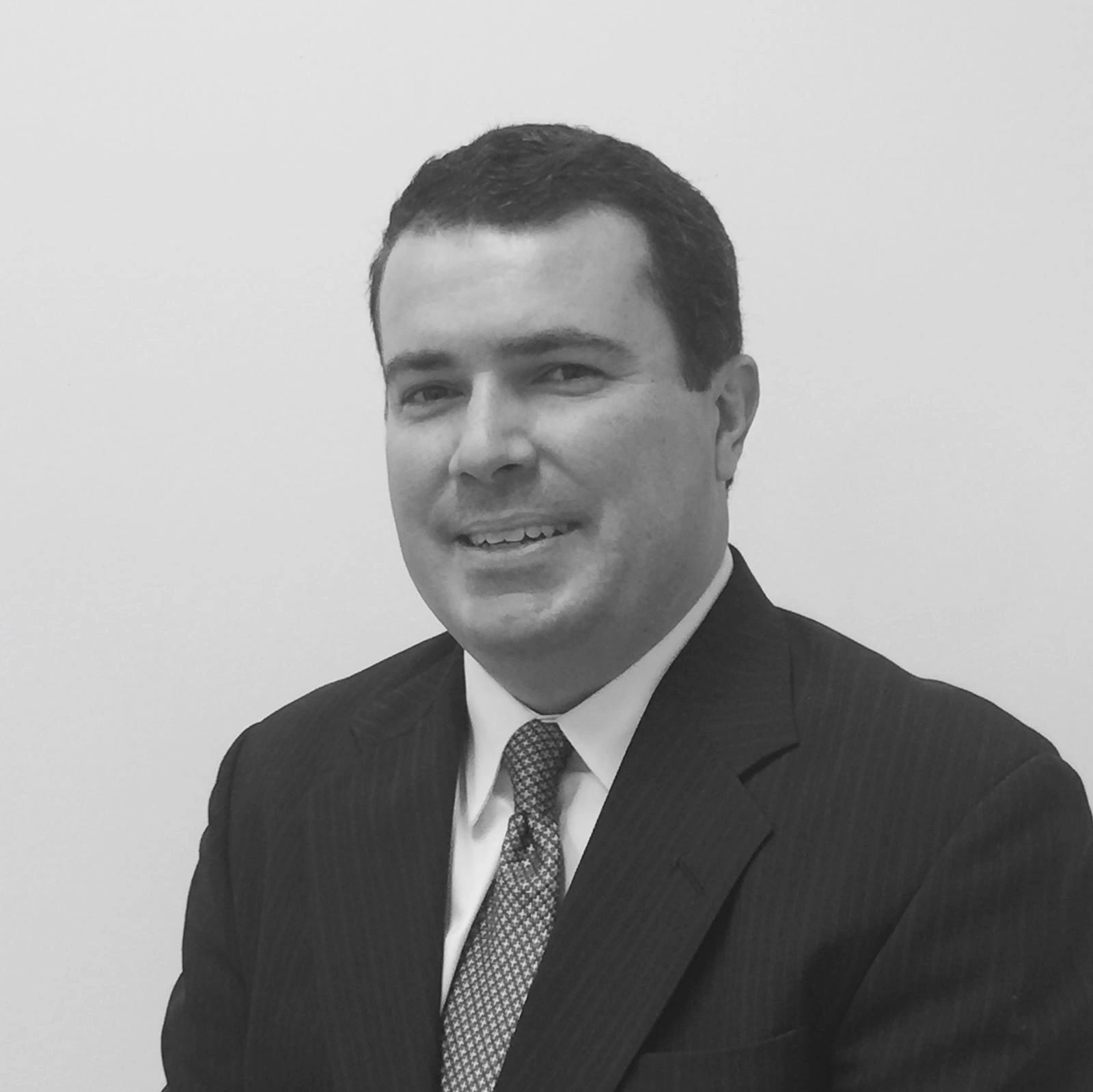 Man in a suit smiling at the camera.